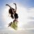 A young girl jumping in front of blue sky and sun stock photo © artjazz