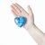 arm holding blue christmas ball in shape of heart isolated on white stock photo © artjazz