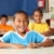 Cheerful primary school children sitting to desks in classroom stock photo © darrinhenry