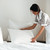 Young hotel maid setting up pillow on bed stock photo © deandrobot