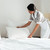 jovem · hotel · empregada · para · cima · travesseiro · cama - foto stock © deandrobot