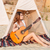 Young beautiful hippie girl sitting with guitar at the beach stock photo © deandrobot