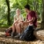 couple sitting on trunk and eating snack after trekking stock photo © diego_cervo