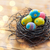 close up of colored easter eggs in nest on wood stock photo © dolgachov