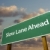 Slow Lane Ahead Green Road Sign Over Clouds stock photo © feverpitch