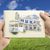 Hands Holding Paper With House Drawing Over Empty Grass Field stock photo © feverpitch