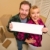 Happy Couple Holding Blank Sign in Room with Packed Boxes stock photo © feverpitch