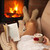 Woman reading a book and enjoying a hot chocolate by the fire stock photo © ilona75
