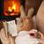 Woman relaxing by the fire with a good book some cookies and hot stock photo © ilona75