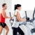 man and woman with elliptical cross trainer at gym stock photo © lunamarina