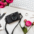 Modern computer keyboard, pink flowers and photo camera on white stock photo © manera