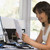 Woman in home office with computer and paperwork smiling stock photo © monkey_business
