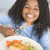 Young girl in kitchen eating chicken and vegetables smiling stock photo © monkey_business