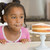 Young girl in kitchen looking at cake on counter stock photo © monkey_business