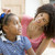 Woman in front hallway fixing young girl's hair and smiling stock photo © monkey_business