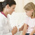 Doctor giving needle to young girl in exam room stock photo © monkey_business