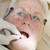 Dentist in exam room fitting dentures on woman in chair stock photo © monkey_business