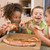 Four young children indoors eating pizza smiling stock photo © monkey_business
