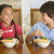 Two young children eating Chinese food in dining room smiling stock photo © monkey_business