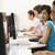 Four people sitting in computer room smiling stock photo © monkey_business