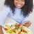 Young girl in kitchen eating salad smiling stock photo © monkey_business