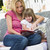 Woman and young girl sitting on patio reading book smiling stock photo © monkey_business