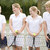 Four young friends with rackets on tennis court smiling stock photo © monkey_business