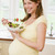 Pregnant woman in kitchen eating a salad smiling stock photo © monkey_business