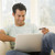 Man in living room using laptop and holding credit card smiling stock photo © monkey_business