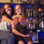 Two young women sitting on a bar counter, toasting the camera stock photo © monkey_business