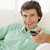 Man in living room holding remote control smiling stock photo © monkey_business