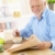 Senior man reading papers at breakfast stock photo © nyul