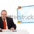 businessman sitting at desk and holding a mobilephone, isolated on white stock photo © ra2studio