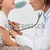 Smiling doctor auscultating a child with a stethoscope in examination room stock photo © wavebreak_media