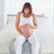 Lovely pregnant female caressing her belly while sitting on a gym ball in her bedroom stock photo © wavebreak_media