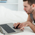 Man using a laptop while lying on his belly in his bedroom stock photo © wavebreak_media