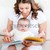 Attentive mother reading a book to her adorable baby sitting in the couch in the living-room stock photo © wavebreak_media