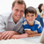 Smiling son and dad using laptop together on the carpet stock photo © wavebreak_media