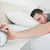 Attractive man being awakened by an alarm clock in his bedroom stock photo © wavebreak_media