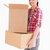 Attractive woman holding cardboard boxes while standing against a white background stock photo © wavebreak_media