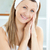 Smiling young woman putting cream on her face in the bathroom at home stock photo © wavebreak_media