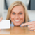 Businesswoman pointing at a card crouching behind her desk looks itno camera in her office stock photo © wavebreak_media