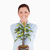 Good looking red-haired female holding a houseplant while standing on a white background stock photo © wavebreak_media