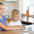 Siblings together with laptop behind the kitchen counter stock photo © wavebreak_media