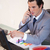 Young businessman talking on the phone while working on statistics stock photo © wavebreak_media
