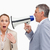 Businessman using a megaphone after his colleague against white background stock photo © wavebreak_media