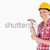 Attractive woman holding a hammer while standing against a white background stock photo © wavebreak_media