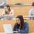 Students in a lecture hall taking notes with one using laptop stock photo © wavebreak_media