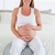Charming pregnant female caressing her belly while sitting on a gym ball in her bedroom stock photo © wavebreak_media