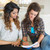 Two women sitting on a couch while looking at a notepad in a kitchen stock photo © wavebreak_media